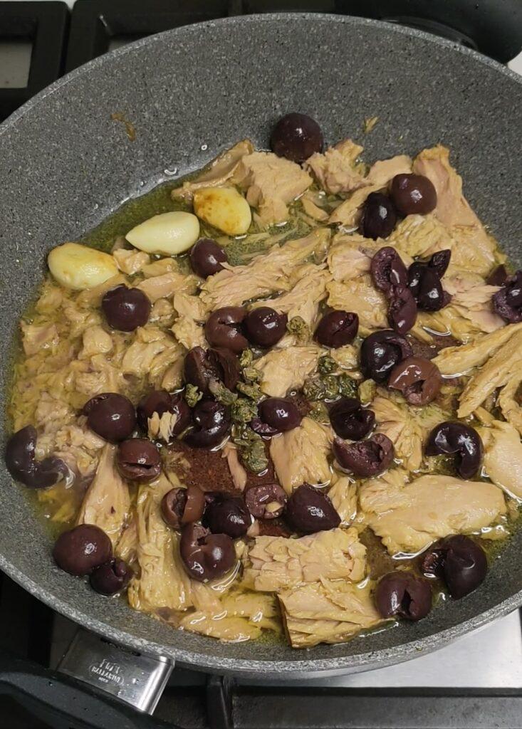 Pan with tuna, black olive, and caper spaghetti in preparation