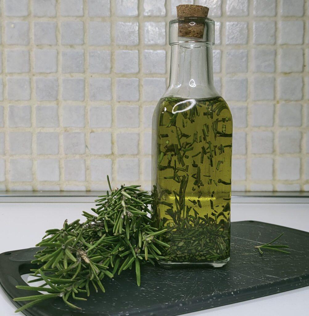 olio al rosmarino pronto nella bottiglia di vetro chiusa con tappo di sughero