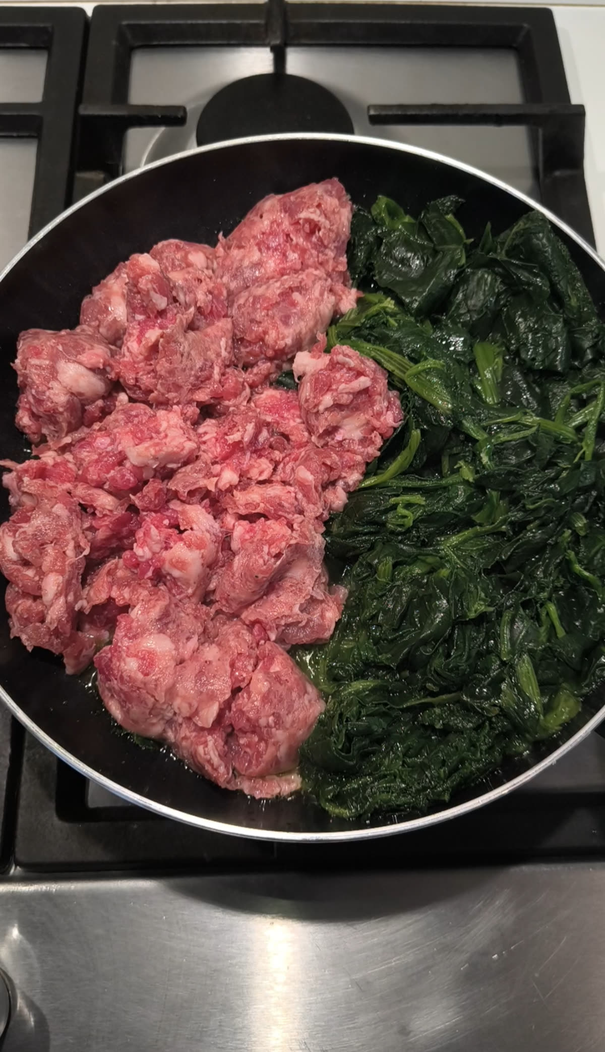 Salsicce e spinaci in cottura