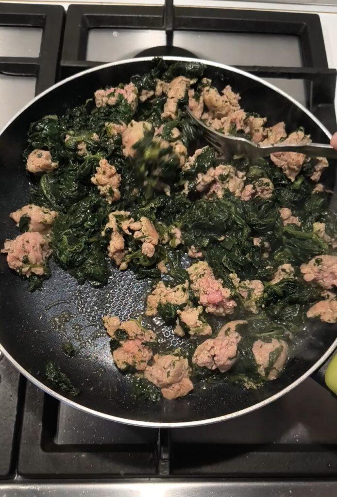 Ripieno di spinaci e salsiccia cotto e ben asciutto pronto per farcire la torta salata