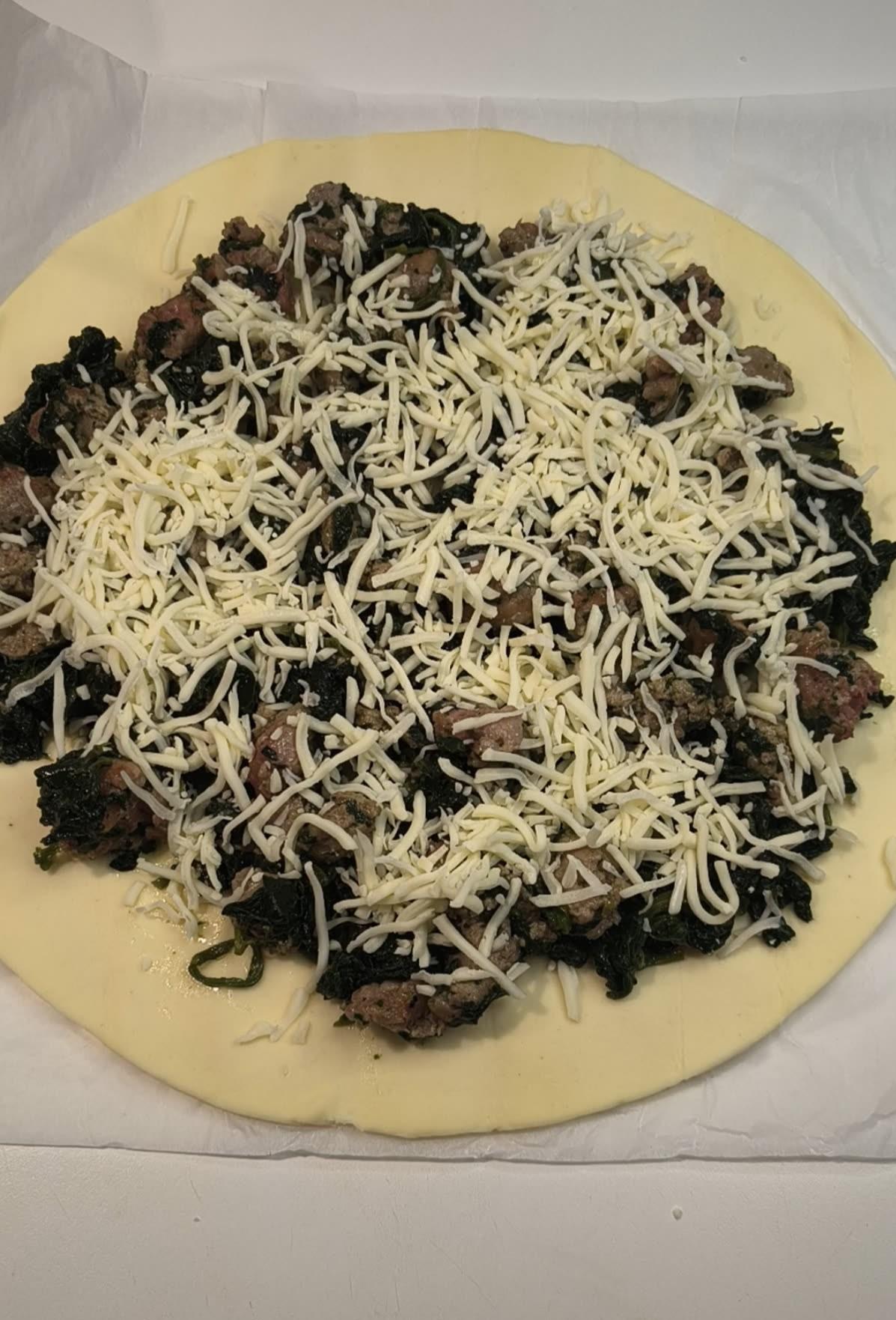Spinaci salsicce mozzarrella sulla pasta sfoglia