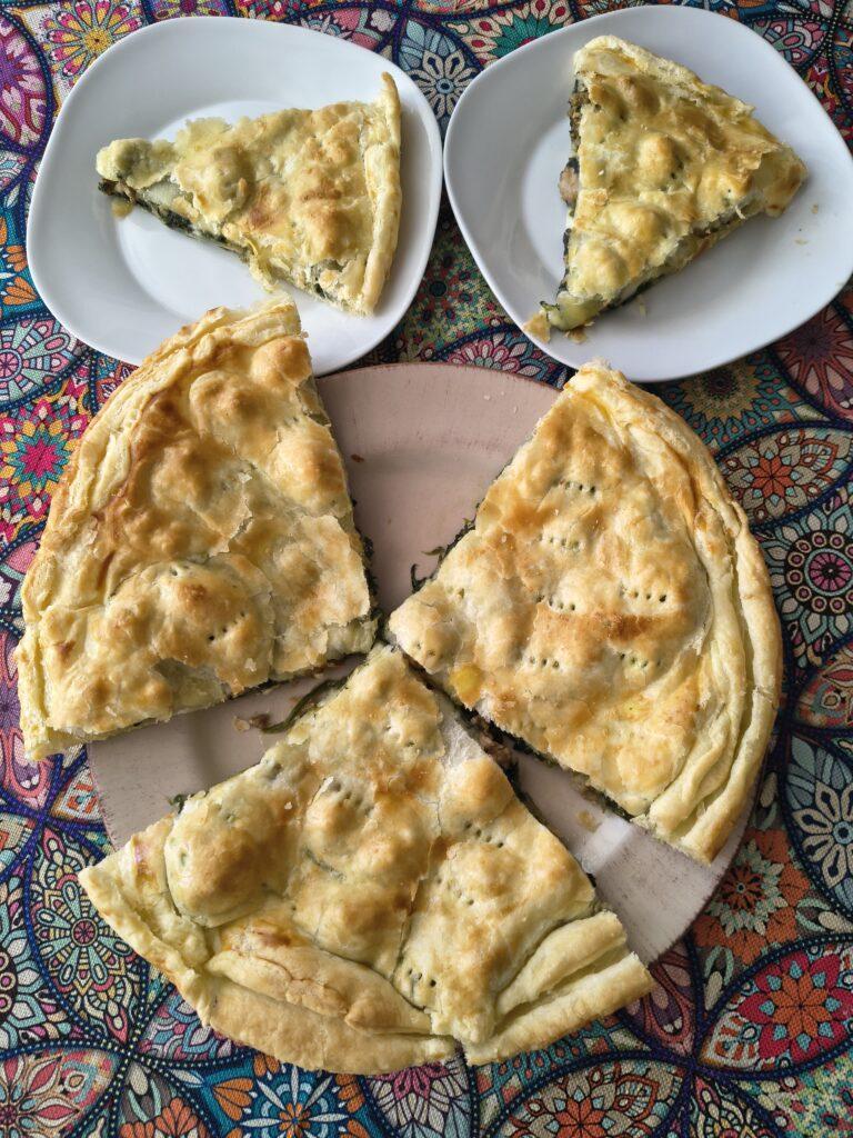 Torta salata spinaci e salsiccia appena sfornata e dorata in superficie
