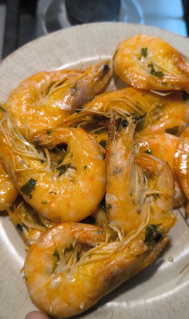 Mazzancolle al limone in cottura con olio extravergine e prezzemolo.